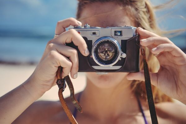 海辺で写真を撮る女の人