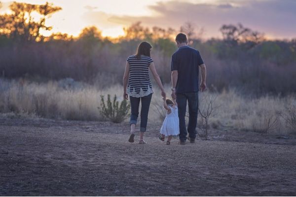 夕方に散歩する女の子と両親